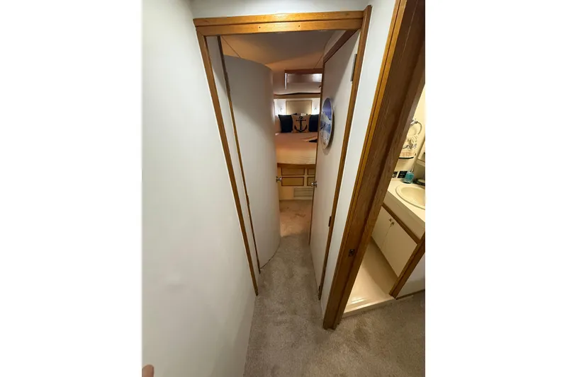 Slide: The Image of 1988 Bertram 43 Flybridge interior hallway with bedroom and bathroom view. - 45