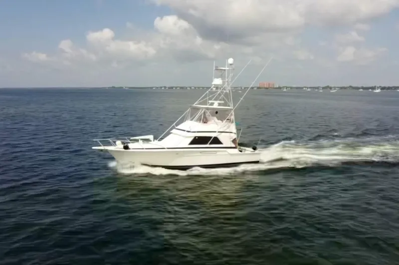 Slide: The Image of 1988 Bertram 43 Flybridge cruising on open water under a partly cloudy sky. - 5