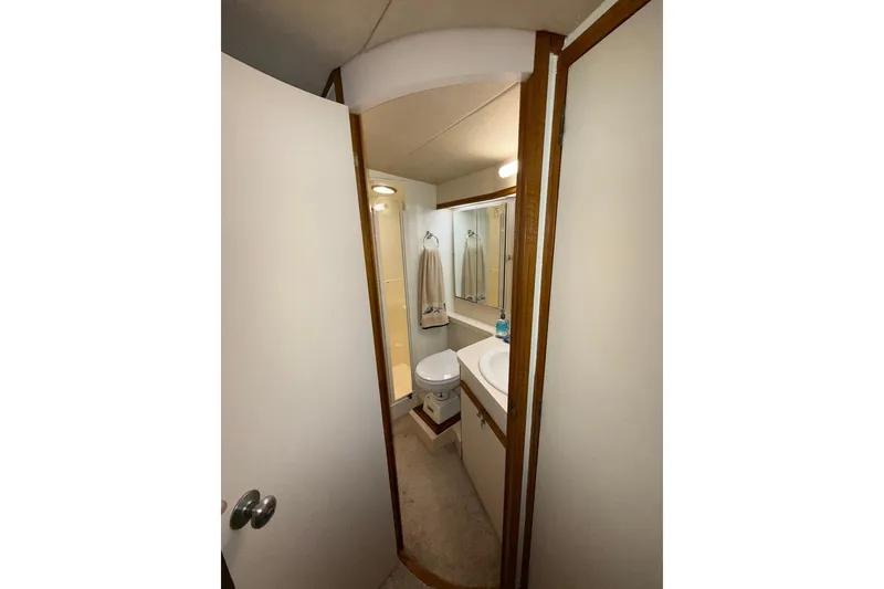 Slide: The Image of Compact bathroom in 1988 Bertram 43 Flybridge yacht, featuring sink, mirror, and towel rack. - 50