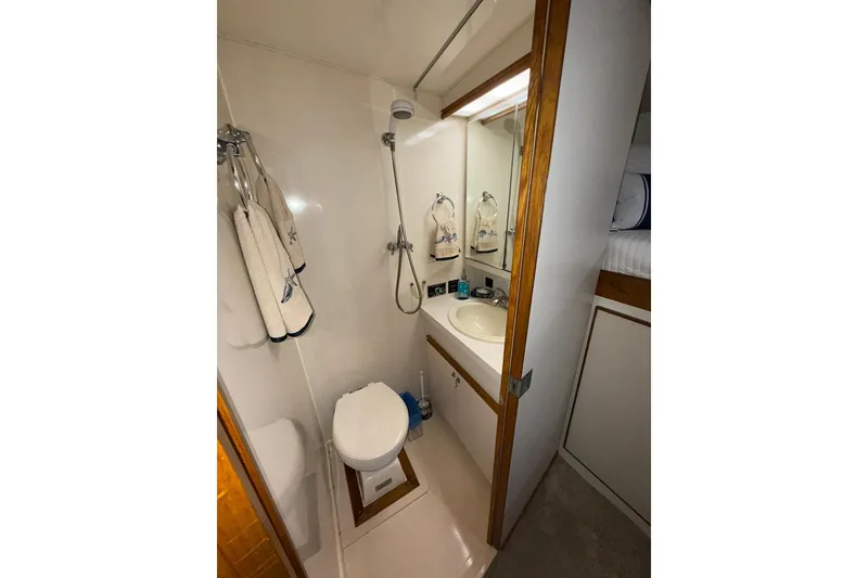 Slide: The Image of Compact bathroom in 1988 Bertram 43 Flybridge yacht with shower, sink, and toilet. - 54