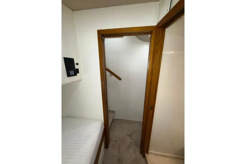 Slide: The Image of Interior view of 1988 Bertram 43 Flybridge, featuring a wooden door and carpeted stairs. - 55