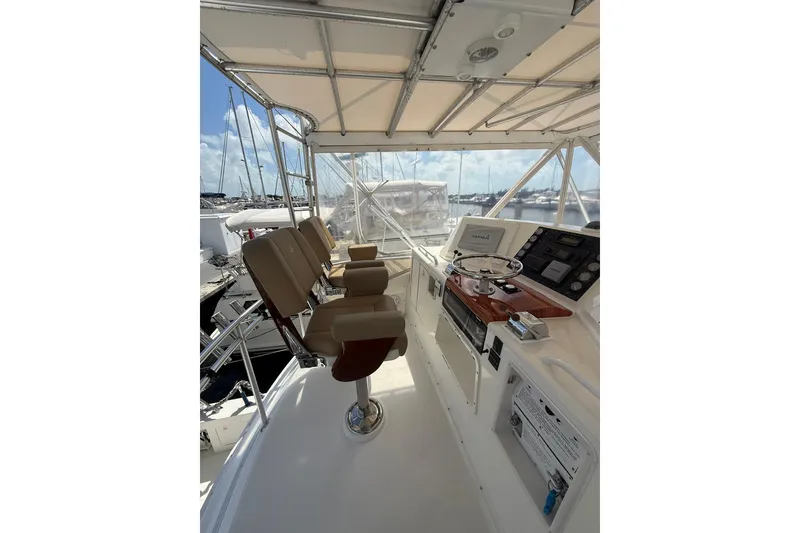 Slide: The Image of 1988 Bertram 43 Flybridge helm with seating, steering wheel, and control panel. - 58