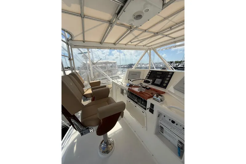 Slide: The Image of 1988 Bertram 43 Flybridge helm with dual seats and navigation controls. - 59
