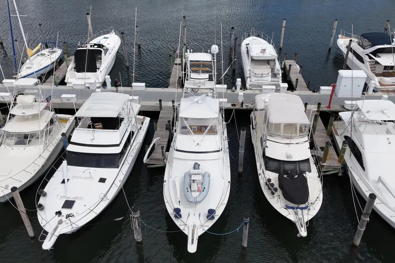 Slide: The Image of 1988 Bertram 43 Flybridge yacht docked among other boats in a marina. - 6