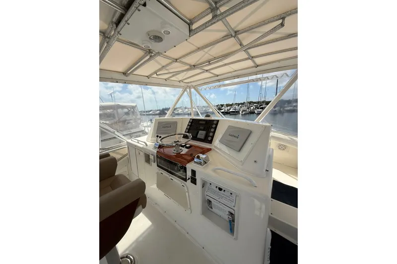 Slide: The Image of 1988 Bertram 43 Flybridge helm with navigation equipment and marina view. - 60