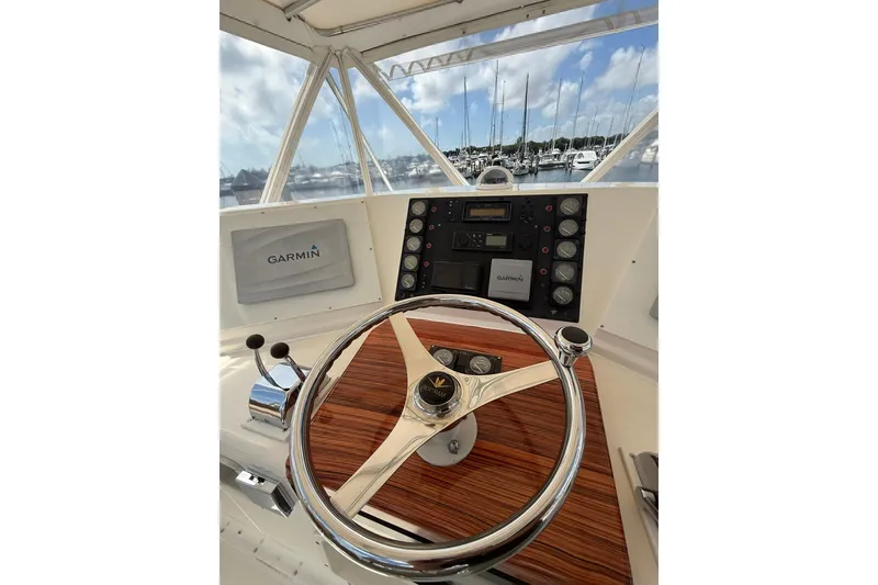 Slide: The Image of 1988 Bertram 43 Flybridge helm with Garmin navigation, marina view in background. - 63