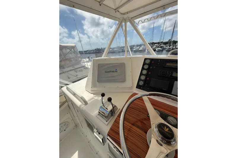 Slide: The Image of 1988 Bertram 43 Flybridge helm with Garmin navigation, marina view in background. - 64