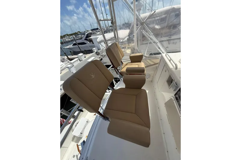 Slide: The Image of 1988 Bertram 43 Flybridge with tan seats, docked at a marina under clear skies. - 65