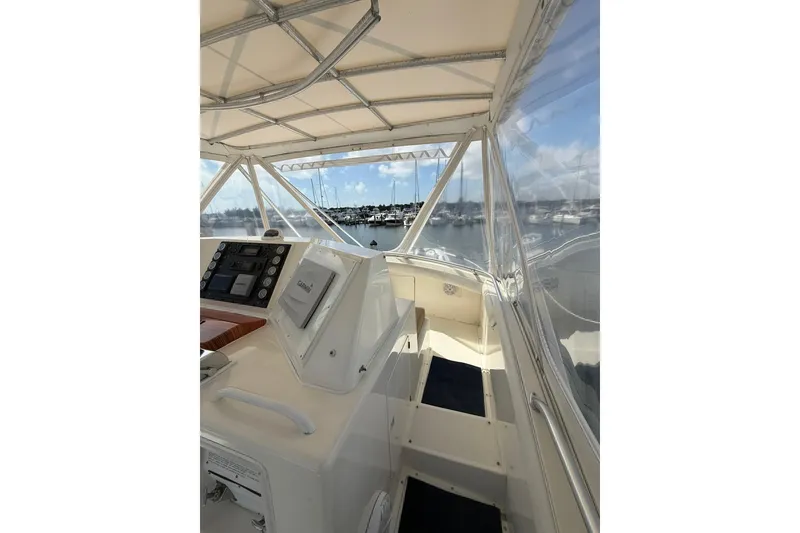 Slide: The Image of 1988 Bertram 43 Flybridge interior with navigation equipment and marina view. - 69