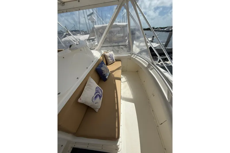 Slide: The Image of 1988 Bertram 43 Flybridge interior with cushioned seating and decorative pillows. - 73