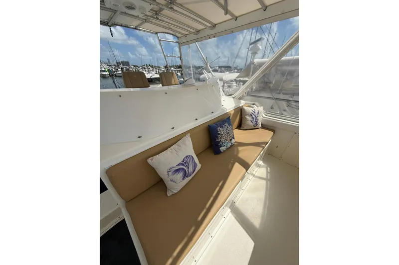 Slide: The Image of 1988 Bertram 43 Flybridge interior with cushioned seating and decorative pillows. - 74