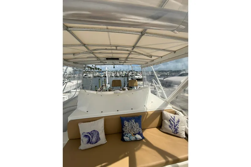 Slide: The Image of 1988 Bertram 43 Flybridge interior with nautical-themed cushions and marina view. - 75