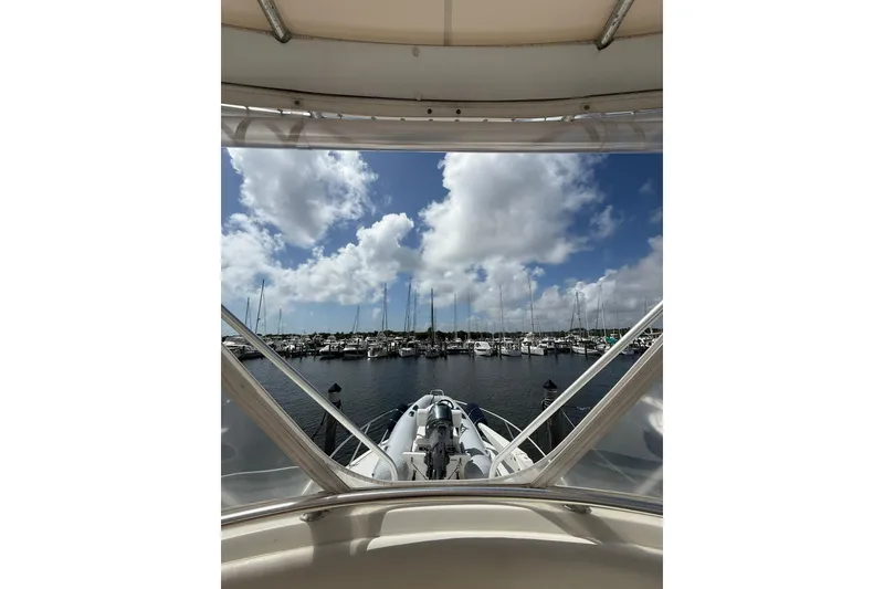 Slide: The Image of View from 1988 Bertram 43 Flybridge, overlooking marina with sailboats and cloudy sky. - 76