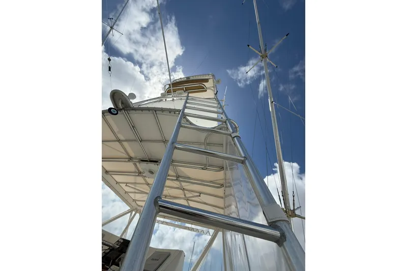Slide: The Image of Ladder view on 1988 Bertram 43 Flybridge against blue sky and clouds. - 78