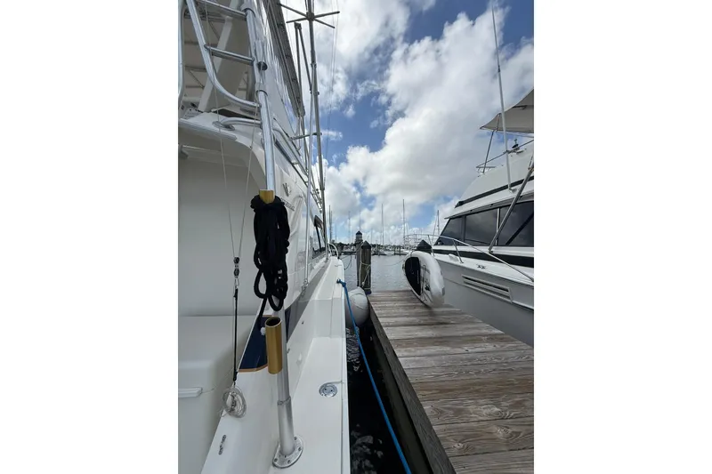 Slide: The Image of 1988 Bertram 43 Flybridge yacht docked at marina under cloudy sky. - 83