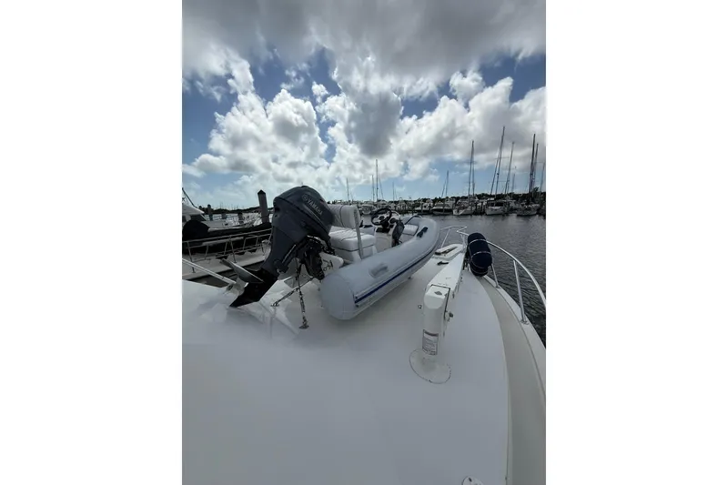 Slide: The Image of 1988 Bertram 43 Flybridge yacht with inflatable boat and Yamaha motor on deck. - 87