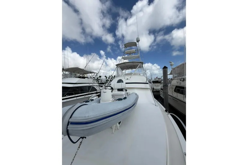 Slide: The Image of 1988 Bertram 43 Flybridge yacht docked under a partly cloudy sky. - 90