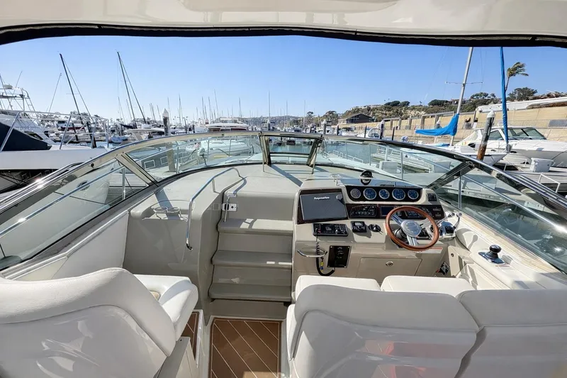 Slide: The Image of 2010 Sea Ray Sundancer 370 yacht cockpit with steering wheel, docked in marina. - 2