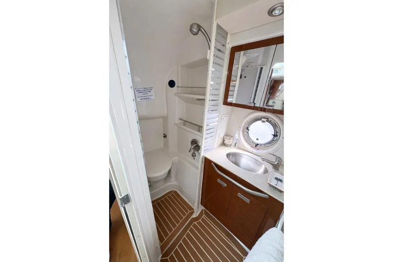 Slide: The Image of 2010 Sea Ray Sundancer 370 bathroom with shower, sink, and wooden cabinetry. - 8