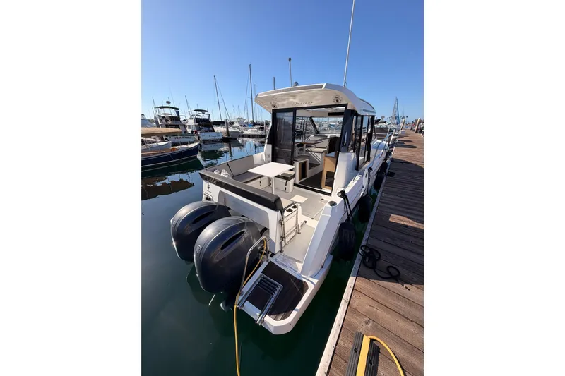 Slide: The Image of 2020 Jeanneau NC 895 boat docked at marina with dual outboard engines. - 13