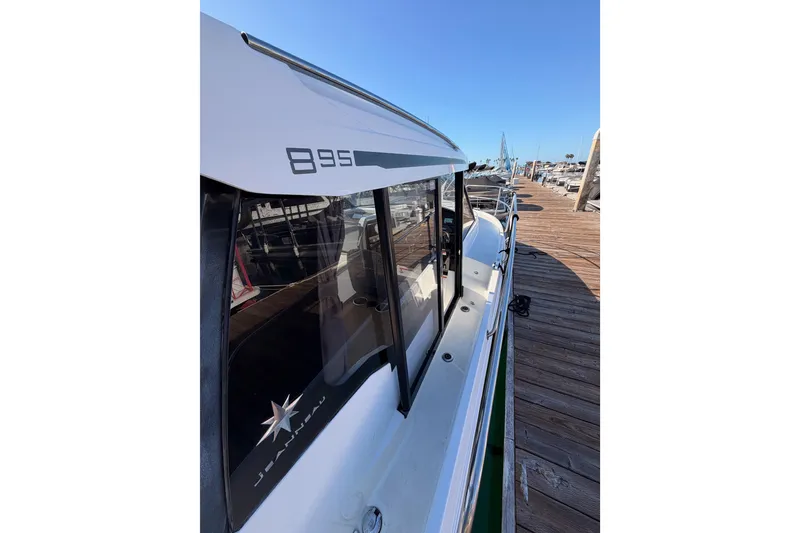 Slide: The Image of 2020 Jeanneau NC 895 boat docked, showcasing sleek design and branding. - 17