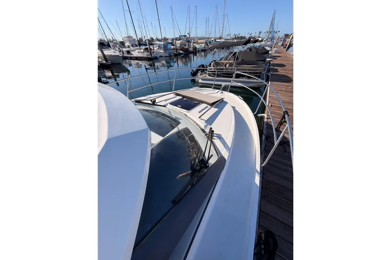 Slide: The Image of 2020 Jeanneau NC 895 docked at a marina, surrounded by sailboats. - 18