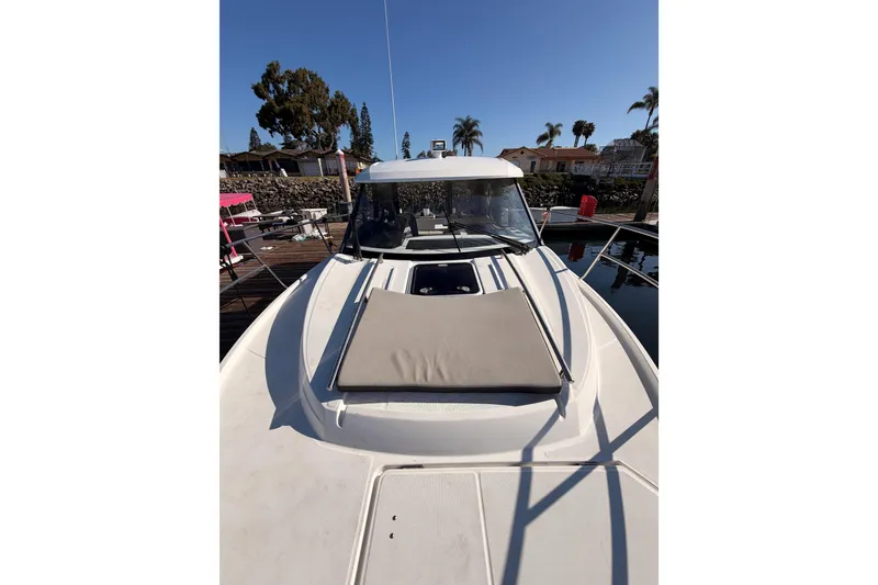 Slide: The Image of 2020 Jeanneau NC 895 boat docked, featuring a sunpad on the bow. - 23