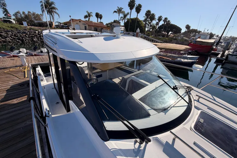 Slide: The Image of 2020 Jeanneau NC 895 docked at marina, showcasing sleek design and spacious cabin. - 25