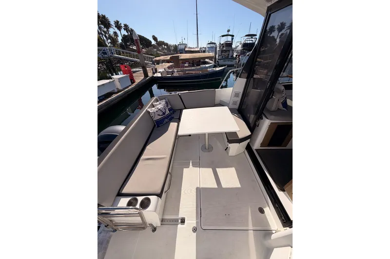 Slide: The Image of 2020 Jeanneau NC 895 boat deck with seating and table in marina. - 30