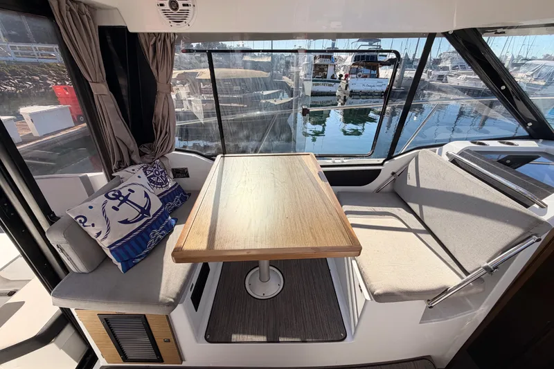 Slide: The Image of Interior of 2020 Jeanneau NC 895 boat with dining area and nautical-themed cushions. - 36