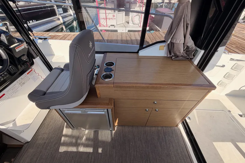 Slide: The Image of 2020 Jeanneau NC 895 interior with helm seat and wooden cabinetry. - 39