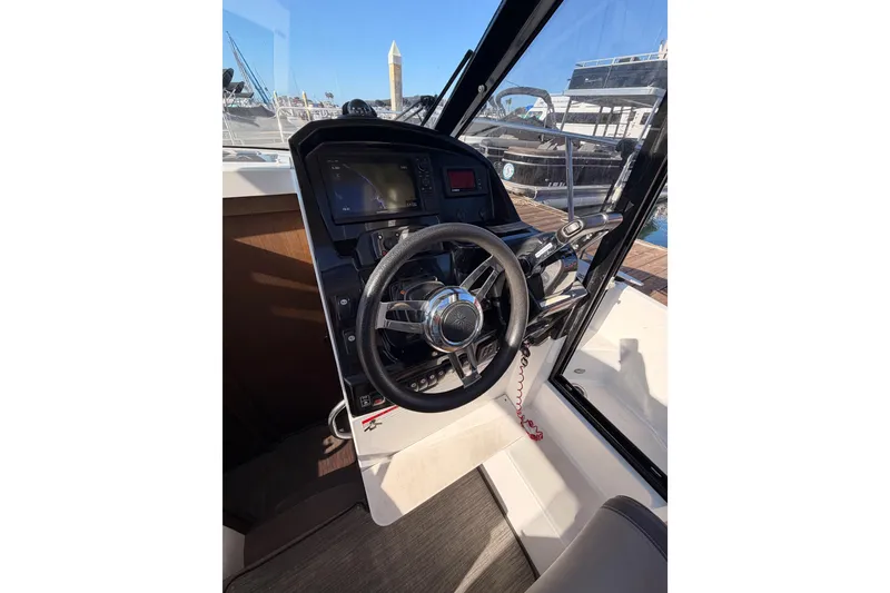 Slide: The Image of 2020 Jeanneau NC 895 helm with steering wheel and navigation controls. - 47