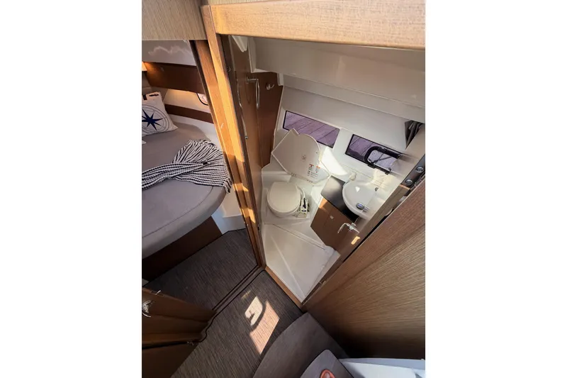 Slide: The Image of 2020 Jeanneau NC 895 interior showing compact bathroom and cozy sleeping area. - 59