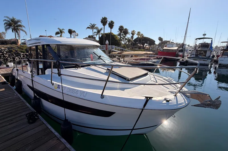 Slide: The Image of 2020 Jeanneau NC 895 boat docked in a marina with palm trees in the background. - 6