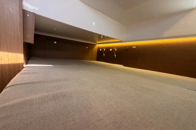 Slide: The Image of 2020 Jeanneau NC 895 cabin interior with cozy bed and ambient lighting. - 68