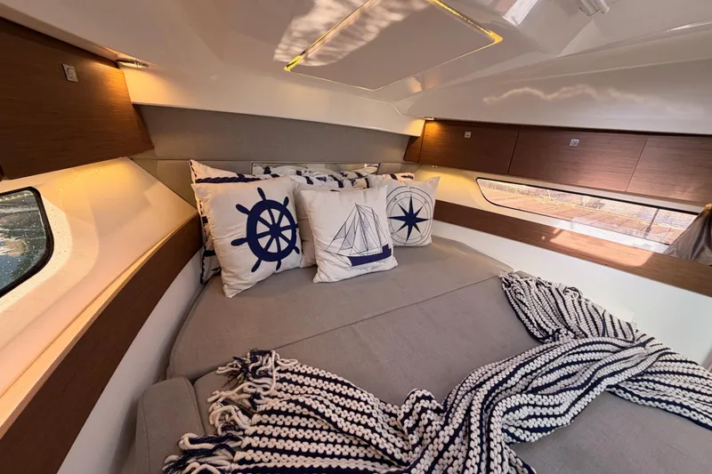 Slide: The Image of Cozy interior of 2020 Jeanneau NC 895 with nautical-themed pillows and blanket. - 74