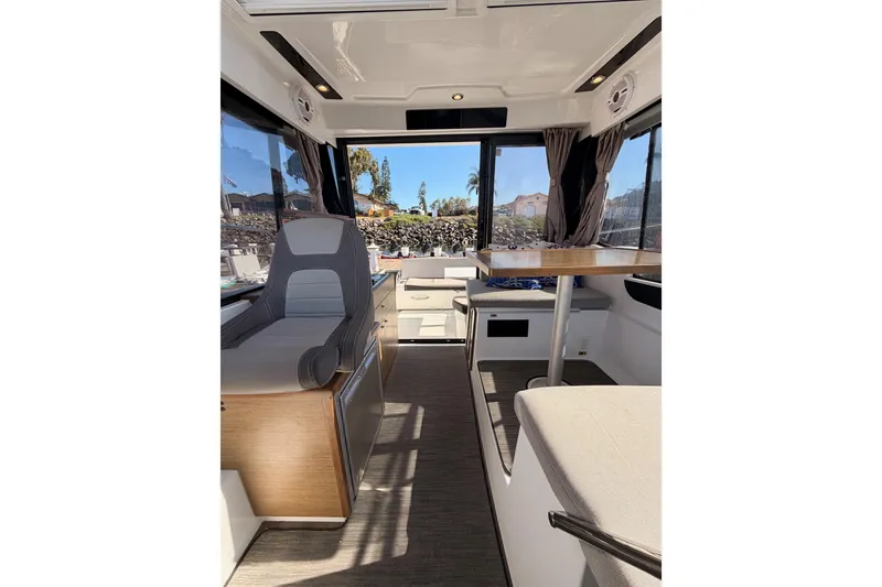 Slide: The Image of 2020 Jeanneau NC 895 interior with seating, table, and large windows. - 78