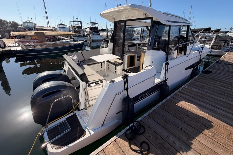 Slide: The Image of 2020 Jeanneau NC 895 boat docked at marina with twin engines and spacious deck. - 8