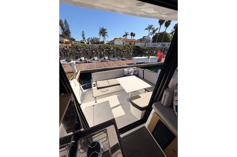 Slide: The Image of 2020 Jeanneau NC 895 boat interior with seating and table, dockside view. - 80