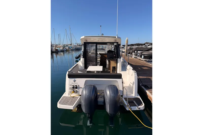 Slide: The Image of 2020 Jeanneau NC 895 boat docked with dual outboard motors in a marina. - 9