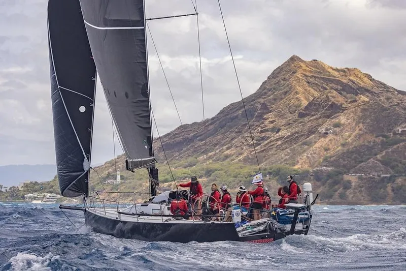Slide: The Image of Sailboat Rogers 46, 2007 model, navigating ocean with mountainous backdrop. - 1