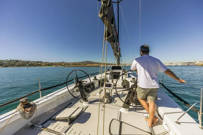 Slide: The Image of Man steering Rogers 46 sailboat on calm waters, clear blue sky, 2007 model. - 10