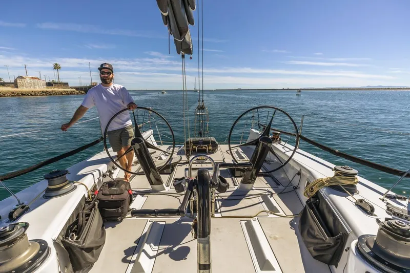 Slide: The Image of Man steering a 2007 Rogers 46 sailboat on a sunny day at sea. - 21