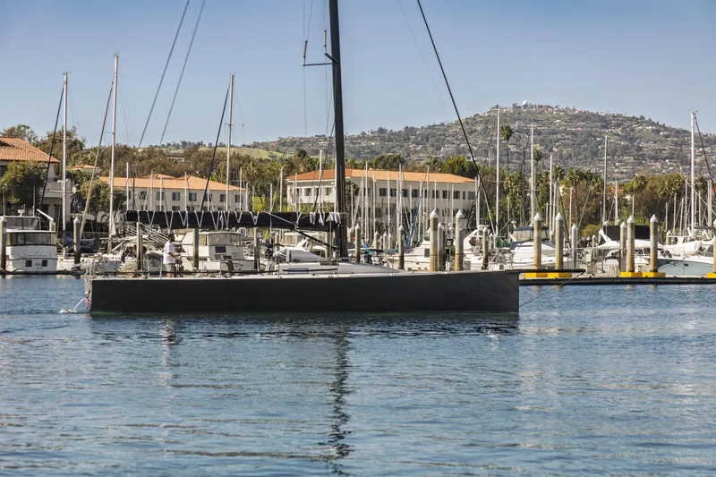 Slide: The Image of Sleek Rogers 46 yacht from 2007 docked in a scenic marina setting. - 3