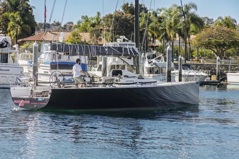 Slide: The Image of Sailboat "Rogers 46" from 2007 docked in a marina with palm trees. - 7