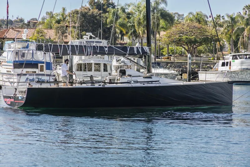 Slide: The Image of Sleek 2007 Rogers 46 sailboat docked in a marina with palm trees in the background. - 8