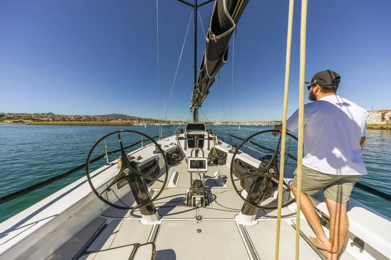 Slide: The Image of Man steering Rogers 46 sailboat, 2007 model, on calm waters under clear blue sky. - 9