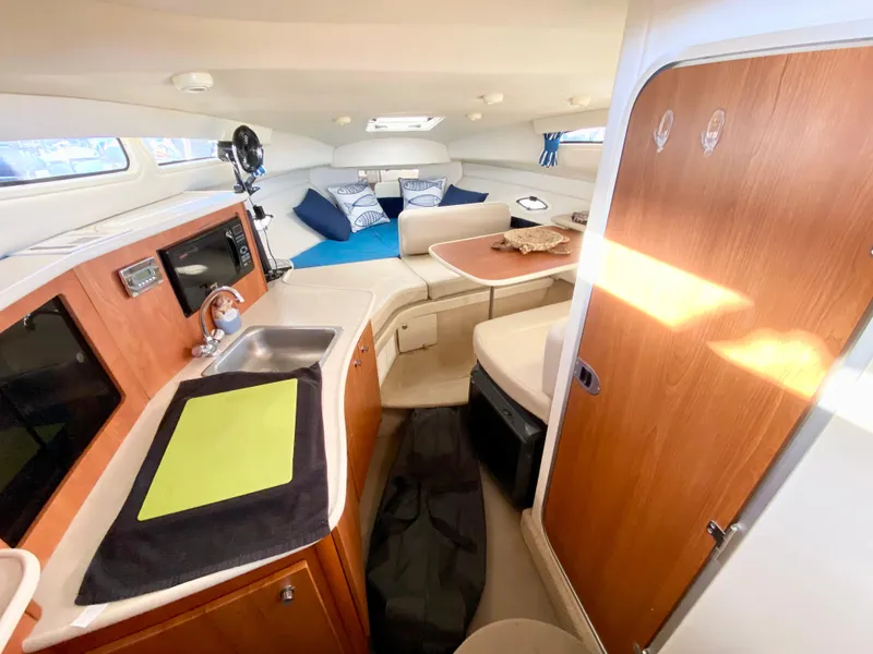 Slide: The Image of Interior of a 2003 Bayliner 265 yacht with kitchen and seating area. - 14