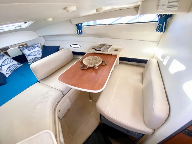 Slide: The Image of Interior of a 2003 Bayliner 265 with cozy seating area. - 15