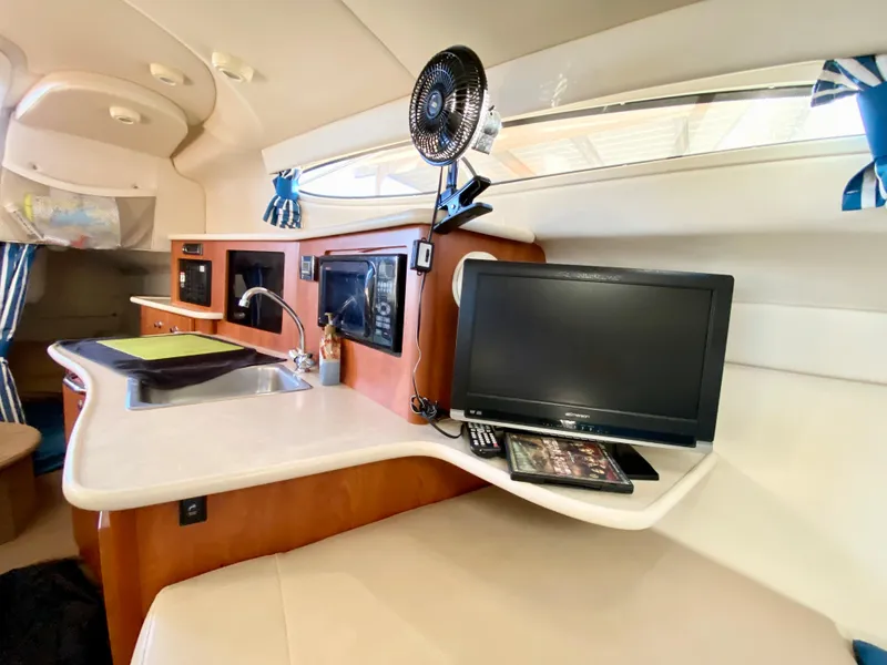 Slide: The Image of Interior of a 2003 Bayliner 265 with kitchenette and TV. - 17